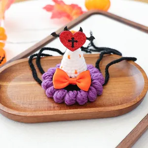 Détail d'un chapeau d'Halloween tricoté pour animaux avec cœur diable et nœud orange