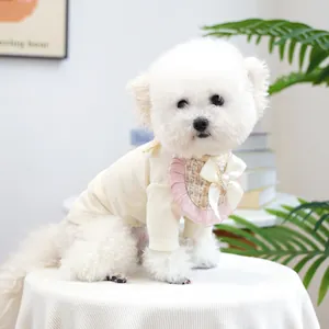 Detail of pink ruffled pet bib with silk bow and heart rhinestone on Bichon Frise