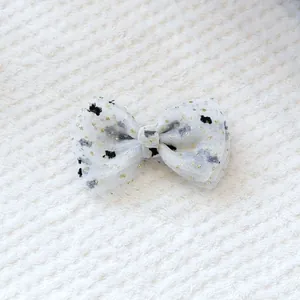 Vue détaillée d'un nœud papillon en maille blanche avec paillettes dorées et oursons