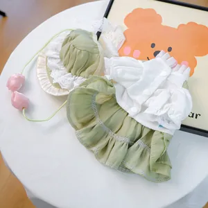 Détail d'une robe pour chiot vert sauge avec volants blancs et chapeau en dentelle
