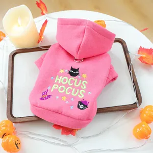 Detailed close-up of pink Halloween pet hoodie with Hocus Pocus embroidery on wood tray