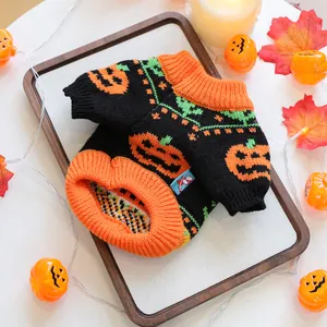 Close-up of Halloween pet knit sweater with orange pumpkin patterns on a cozy wooden tray