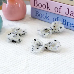 Lot de trois nœuds en tulle blanc avec motifs de cœurs sur une fourrure blanche