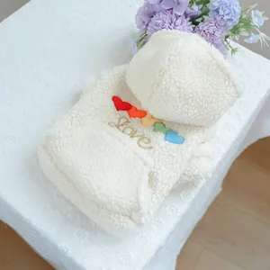 Detail of soft fleece pet hoodie featuring colorful rainbow hearts and Love embroidery