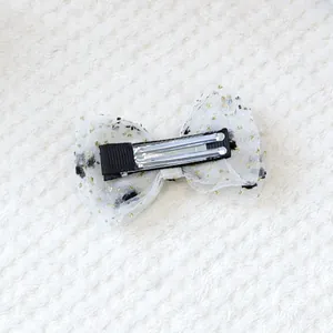 Détail du nœud en résille blanche à pois noirs et paillettes dorées pour petits animaux