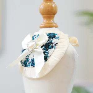 Close-up of blue tweed pet bib with cream satin bow and heart pearl center detail
