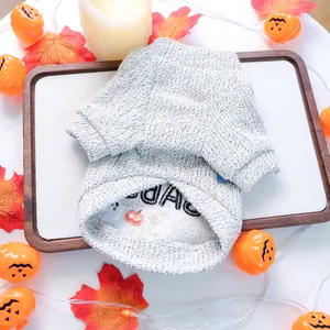 Detail of grey cable-knit pet sweater with Halloween pumpkin and ghost embroidery