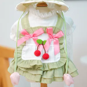 Détail de robe pour chien vert sauge avec nœuds cerise et chapeau assorti