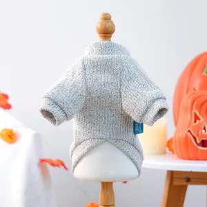 Close-up of grey cable-knit pet sweater with PETCIRCLE tag and Halloween pumpkin decor