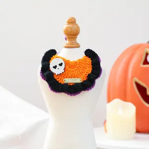 Detail of handmade crochet orange pet collar with skull patch and pumpkin decor