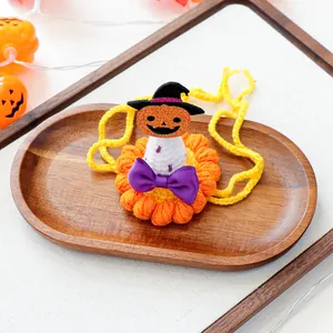 Détail d'une écharpe crochetée Halloween pour animaux avec citrouille et nœud