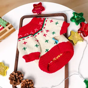 Close-up of pet Christmas sweater with red and green knit patterns and ribbed cuffs