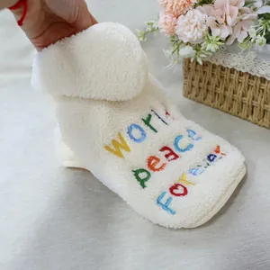Dettaglio del gilet bianco in pile per cani con ricamo colorato World Peace Forever