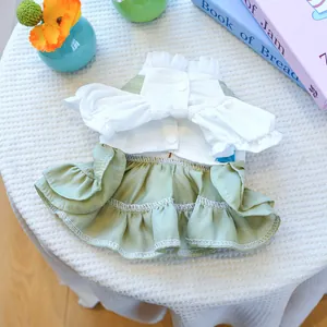 Robe pour petit chien à texture gaufrée et volants superposés sur un bureau blanc plat
