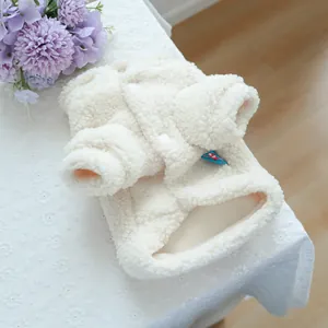 Detail of soft white lamb wool texture and round buttons on cozy pet winter coat