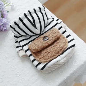 Detail of striped pet hoodie with plush brown pocket and decorative button on lace background