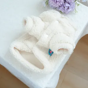 Dettaglio del cappotto in pile sherpa bianco con texture morbida e chiusura a bottoni