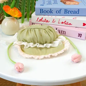 Détail du bonnet vert clair pour animaux avec dentelle et cordons en forme de tulipe