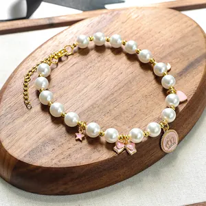 Vue détaillée du collier de perles pour animaux avec pendentifs étoile et nœud rose