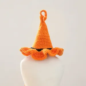 Détail d'un chapeau de sorcier orange tricoté à la main pour animaux avec bande noire pour Halloween