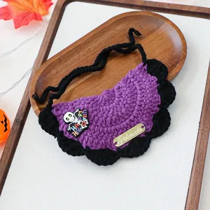 Macro detail of hand-knitted purple Halloween pet bandana with Happy Halloween charm