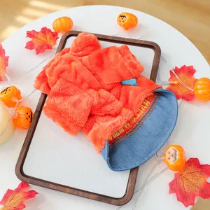 Detail van een pluche oranje hondenjas met blauwe denim kraag voor Halloween thema