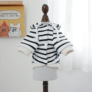 Detail of striped pet hoodie with white drawstrings and button closure on model