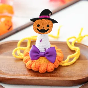 Détail d'un chapeau d'Halloween au crochet pour animaux avec mini sorcière et citrouille