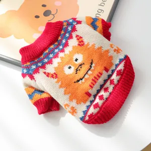 Detail of colorful knitted pet sweater with orange monster jacquard and ribbed red cuffs