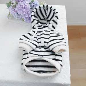 Detail of a black and white striped pet hoodie with white drawstring and soft fleece texture