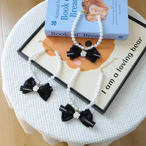 Collier élégant en perles pour animaux avec nœud noir, pendentif camélia et fermoir doré