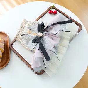 Dettaglio del fermaglio per capelli in pizzo rosa con perla e fiocco di raso
