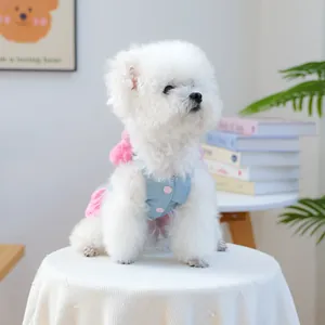 Detail of pink plaid and blue denim pet dress with plush pompom and buttons