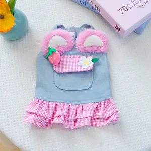 Detail of pet denim dress featuring plush ears and strawberry floral decorations