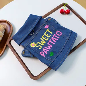 Detail of denim dog vest featuring Sweet Pawtato embroidery and metal D-ring for leash