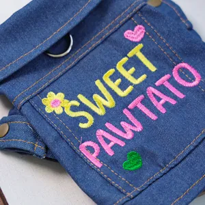 Detail of denim pet jacket featuring sweet pawtato embroidery and metal D-ring buckle