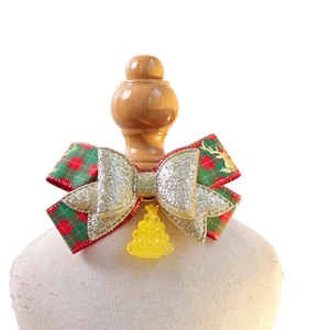 Christmas dog bandana with red plaid bow and small tree charm on a mini display stand