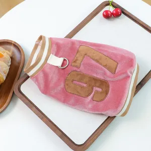 Detailed view of pink velvet pet vest with embroidered number 75 and D-ring harness
