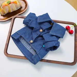 Detail of pet denim jacket featuring dark blue fabric and decorative brown buttons