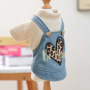 Detailweergave van beige gebreide trui en blauwe denim rok met luipaardprint hart
