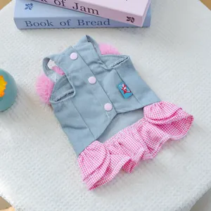 Detail of pet dress featuring blue denim top with pink pom-poms and checkered ruffle skirt