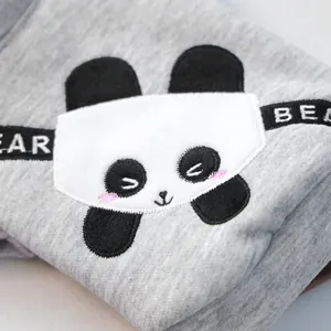 Détail d'un sweat à capuche gris pour chien avec broderie panda et texte BEAR
