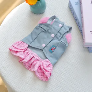 Detail of pet denim dress with pink plaid ruffle skirt and plush trim on white cloth