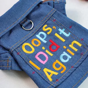 Dettaglio giacca di jeans per cani con ricamo colorato e anello a D in metallo resistente