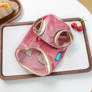 Macro view of warm pink velvet pet vest with quilted lining and ribbed edges