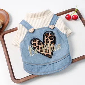 Detail van gebreide trui en denim vest voor huisdieren met luipaardhart en borduur