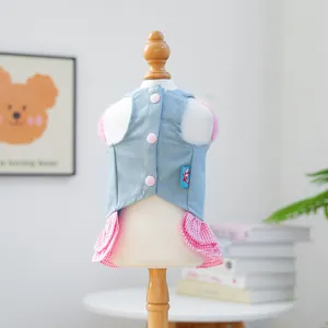 Detail of pet denim dress with pink ruffled plaid skirt and soft plush strawberry accents