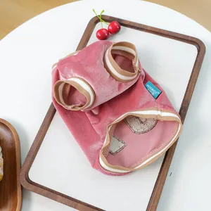 Detailed macro view of pink velvet pet clothes with ribbed cuffs and PETCIRCLE logo