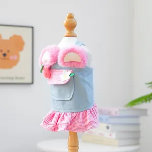 Detail of pet dress featuring blue denim stitching with pink plaid ruffle and floral patch