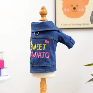 Detail of blue denim pet coat featuring Sweet Pawtato embroidery and metal D-ring for leash